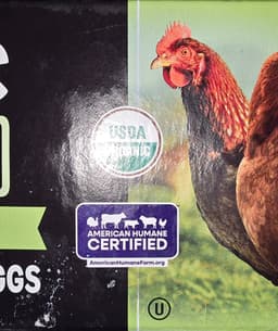 A picture of a chicken on an egg carton close up to show the organic Certification decal and the certified humane indicator.  