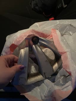 Trash bag full of cans and pieces of a hub cap from an old car accident